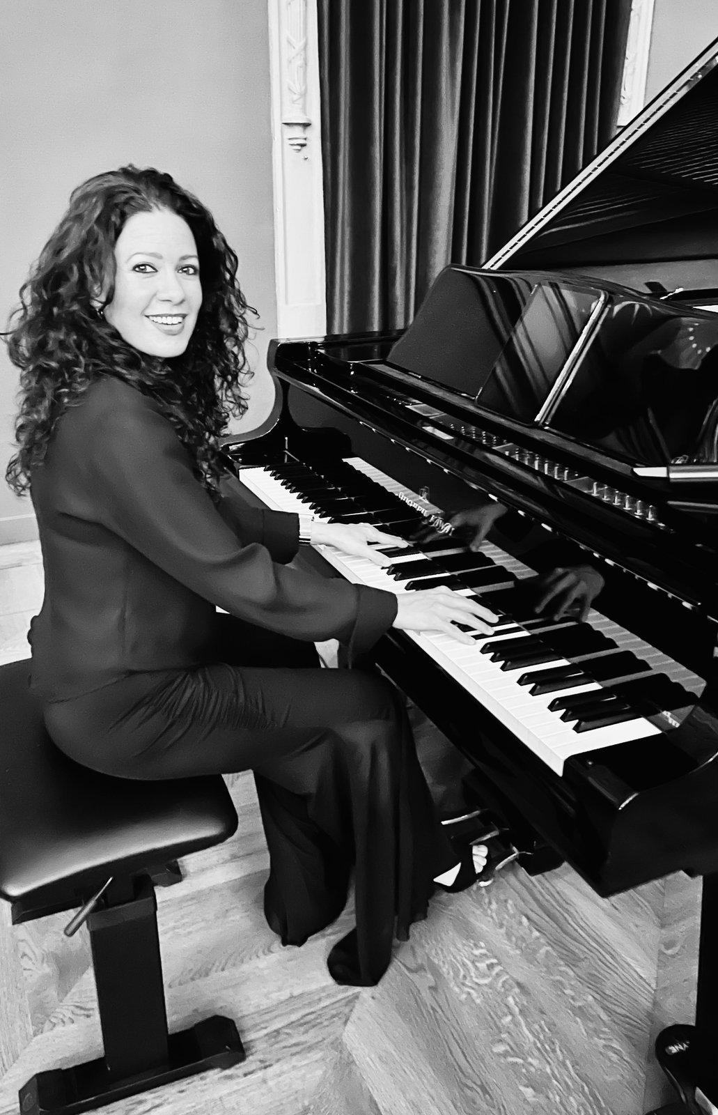 Joanna González al piano de cola, blanco y negro